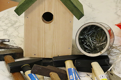 Grootouders en kinderen timmeren nestkastjes