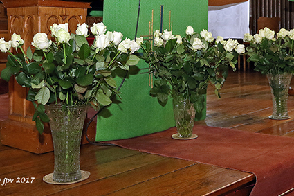 Kaarsjes en witte rozen voor overleden vrienden